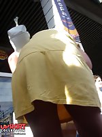 24 pictures - Yellow mini cannot save her from being voyeured. Up skirt